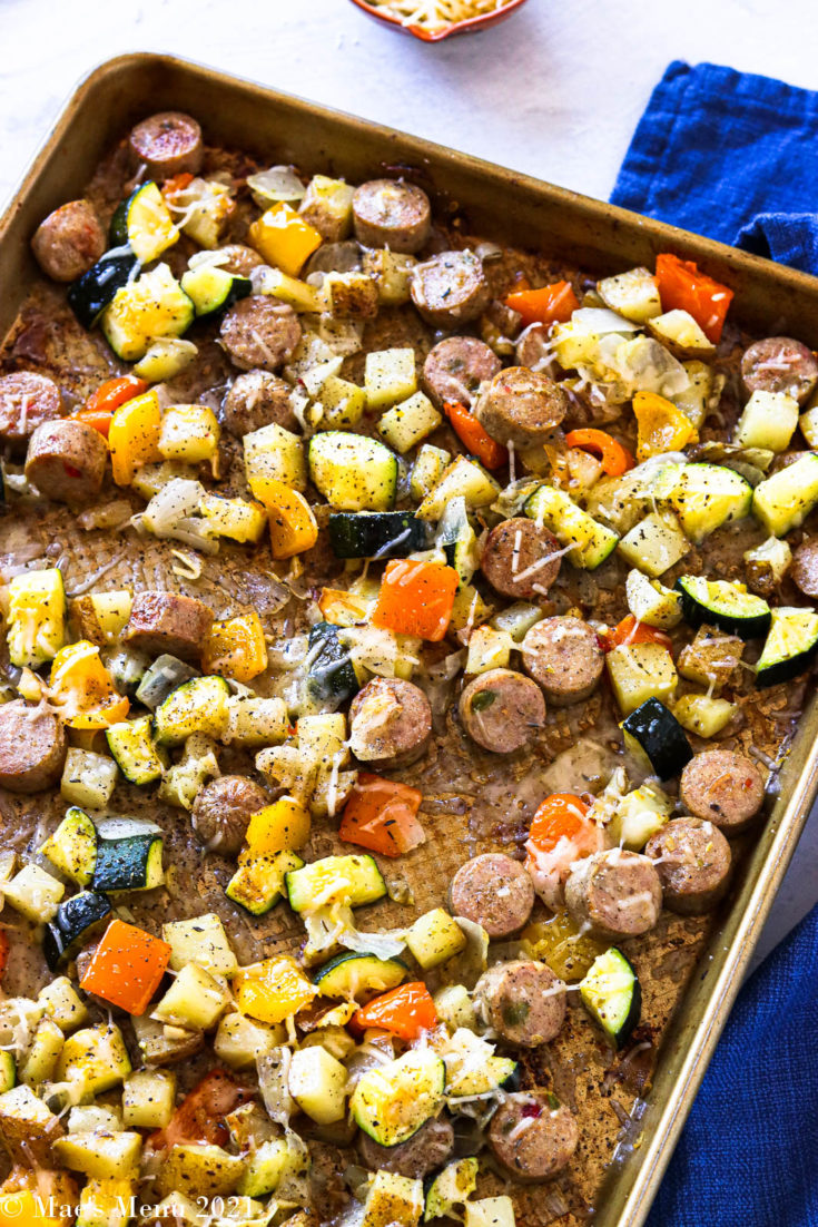 An overhead shot of a sheet pan of roasted sausage and veggies