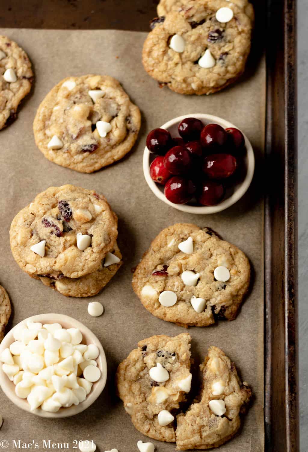White chocolate cranberry cookies on a baking tray with the chips and cranberries