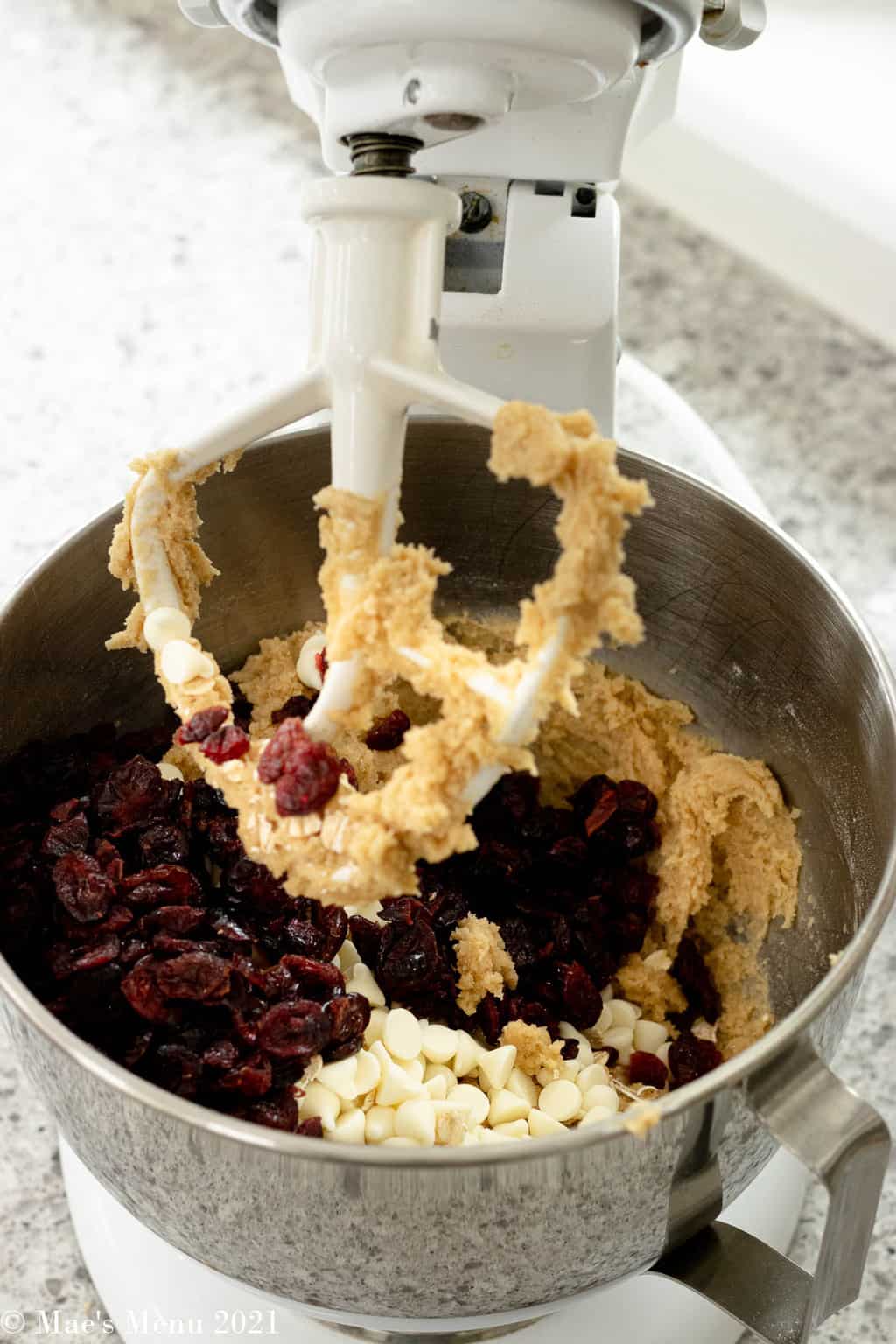 Adding the dried cranberries and white chocolate chips to the cookie batter