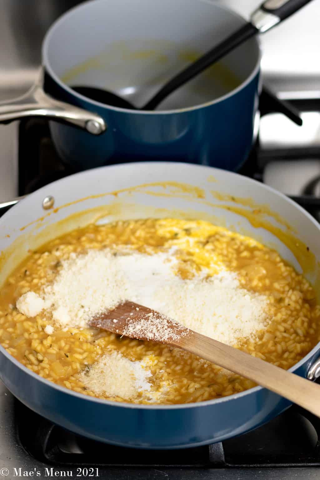 Stirring half and half and parmesan cheese into the pumpkin risotto