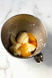 An overhead shot of a mixing bowl of butter and eggs