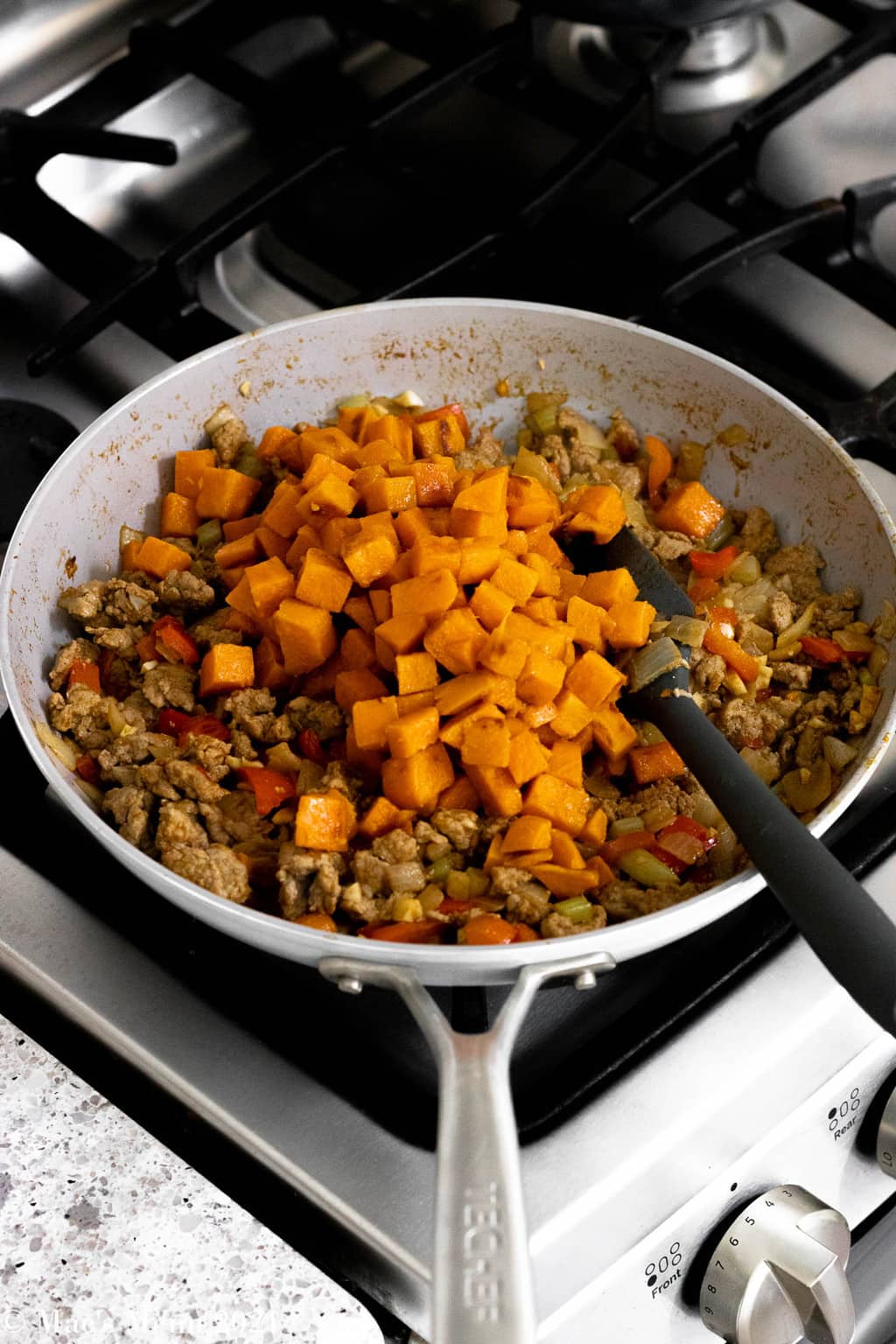 A side angled shot of a skillet of the ground turkey with sweet potatoes.