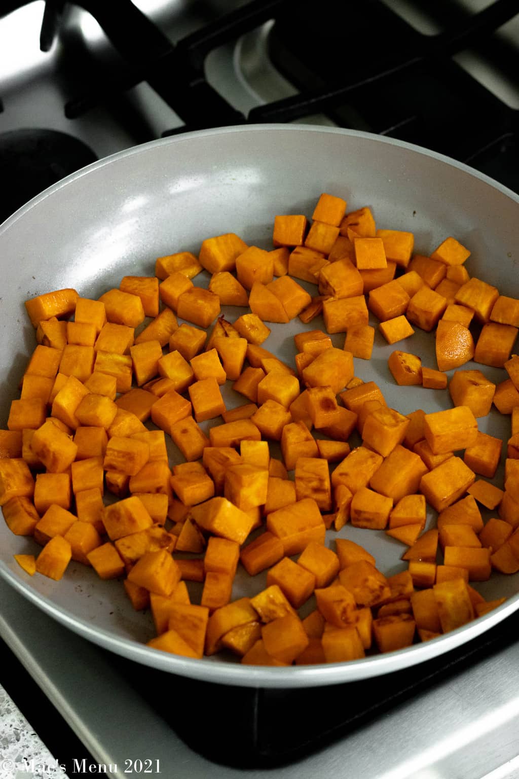 A side shot of a pan of cubed sweet potatoes.