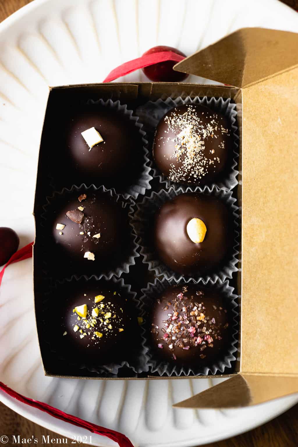 An up-close overhead shot of a box of dark chocolate truffles.