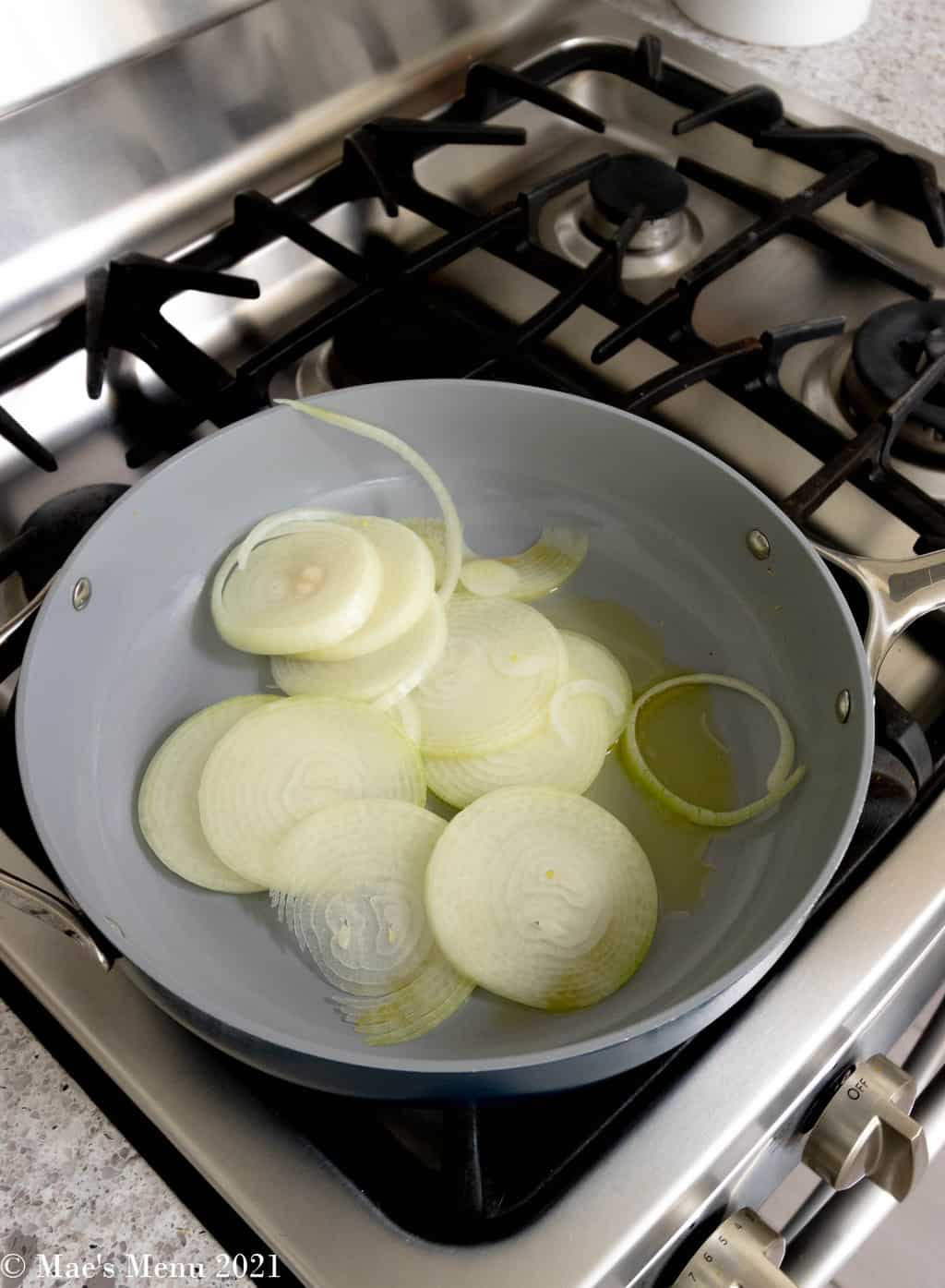 Onions and olive oil in a pan on the gas range.