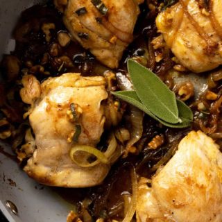 An up-close overhead shot of a pan of chicken with brown butter sage sauce.