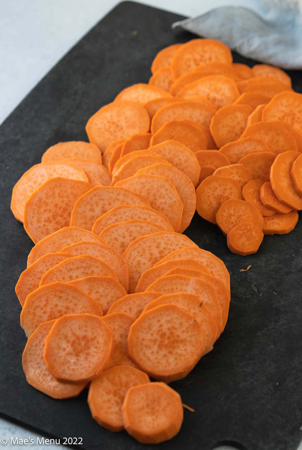 A cutting board of sliced sweet potatoes.