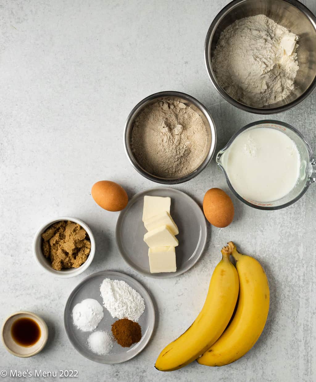All of the ingredients for the banana waffles, flours, buttermilk, eggs, butter, light brown sugar, bananas, vanilla extract, baking soda and baking powder, salt, and cinnamon