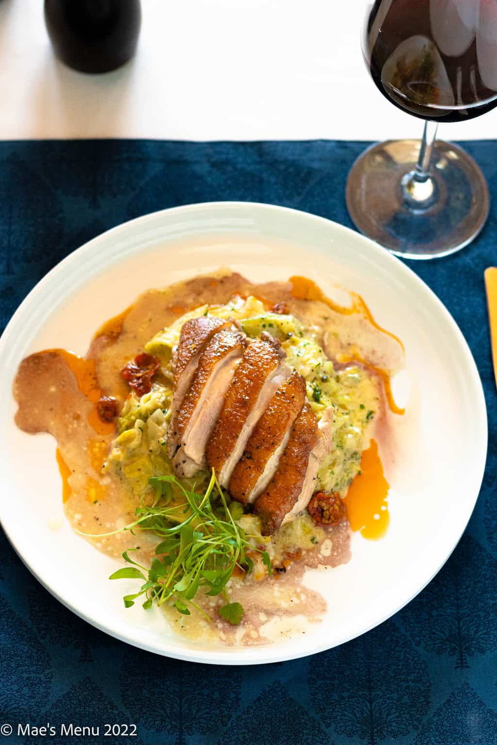 A plate of seared duck on creamed cabbage with pan sauces.