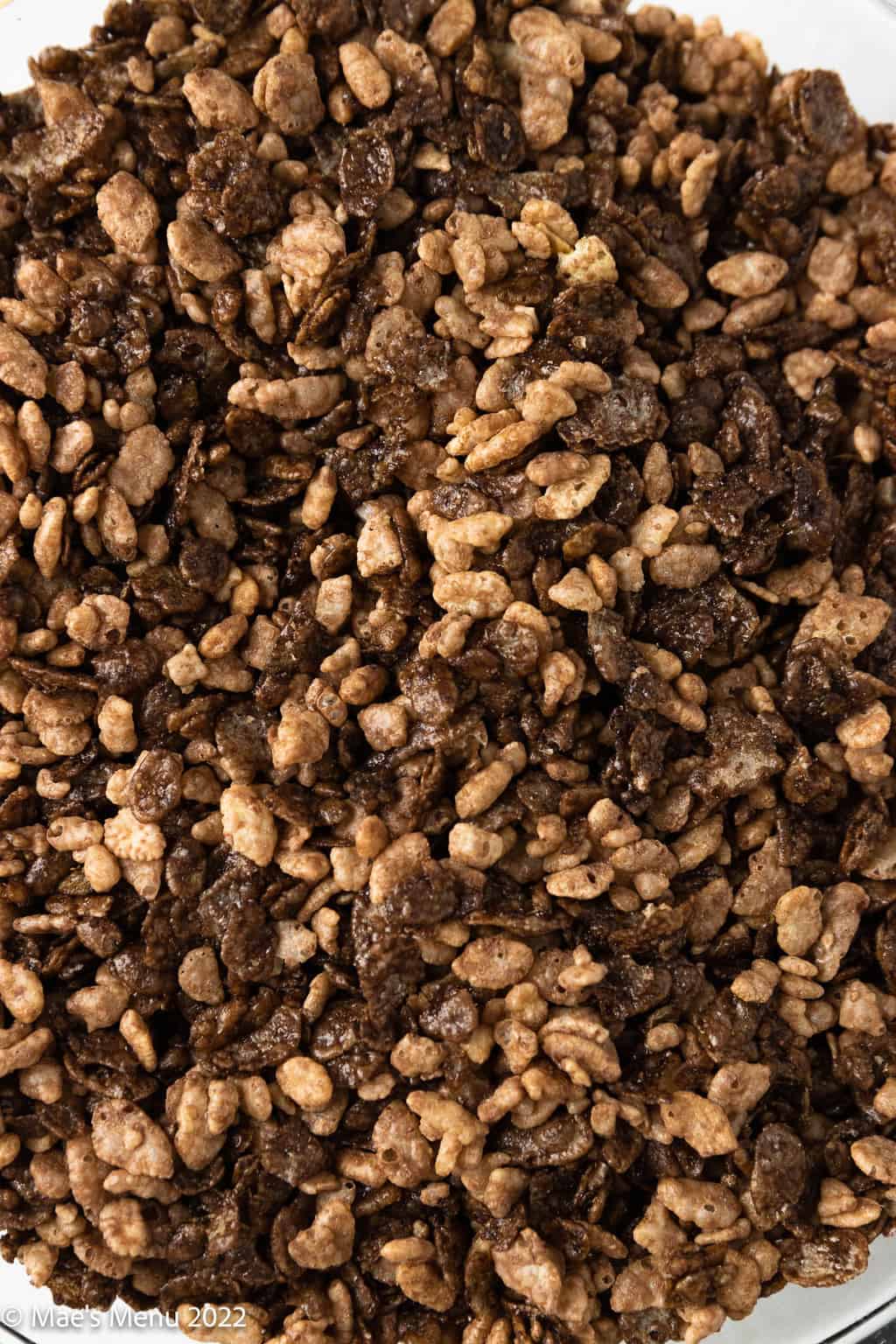 An up-close overhead shot of a bowl of cocoa crisps and cocoa pebbles.
