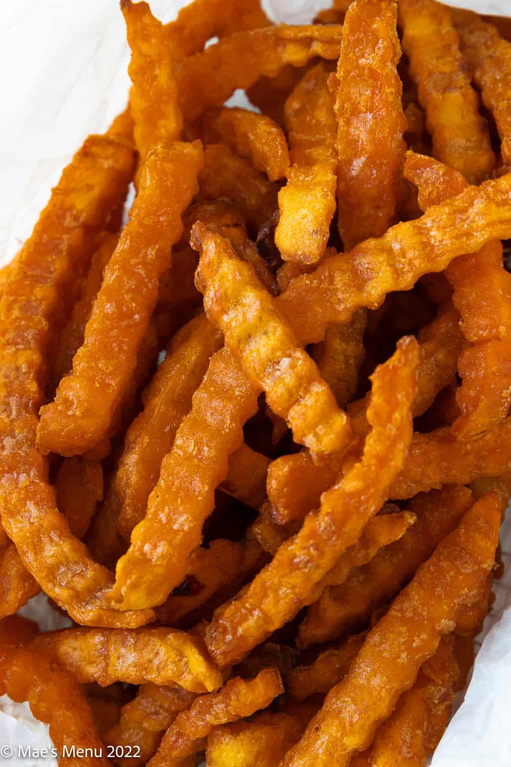 An up-close overhead shot of a basket of sweet potato fries.