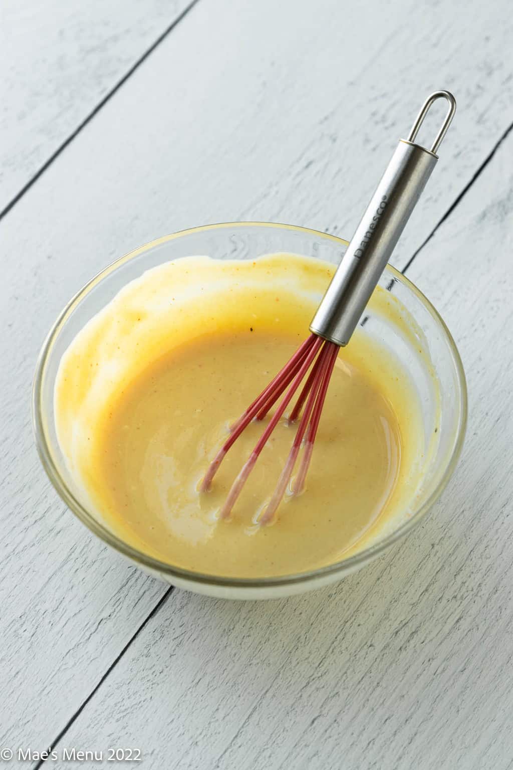 A small mixing bowl of honey mustard dip.