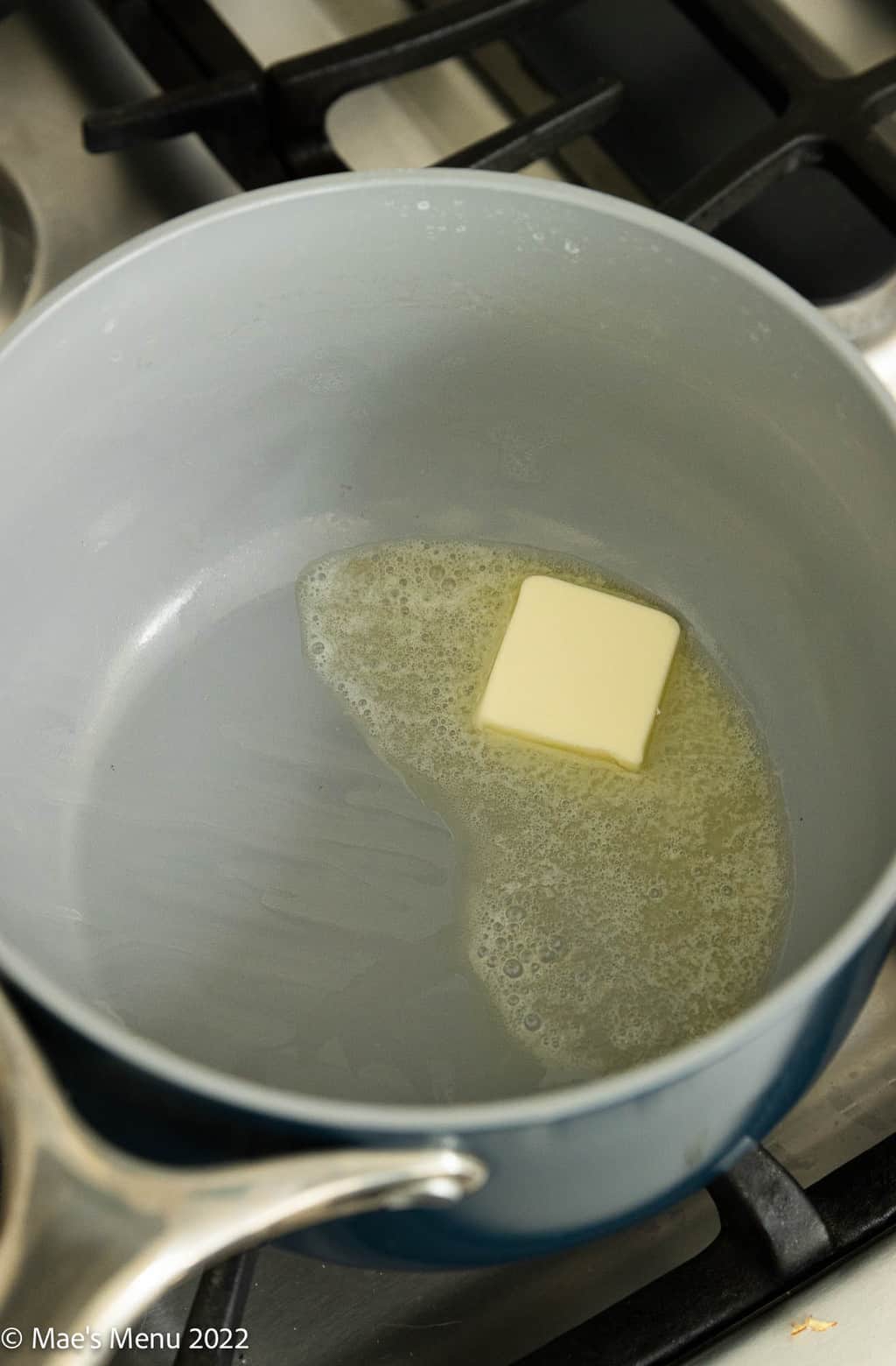 An overhead shot of a saucepan with melted butter in it.