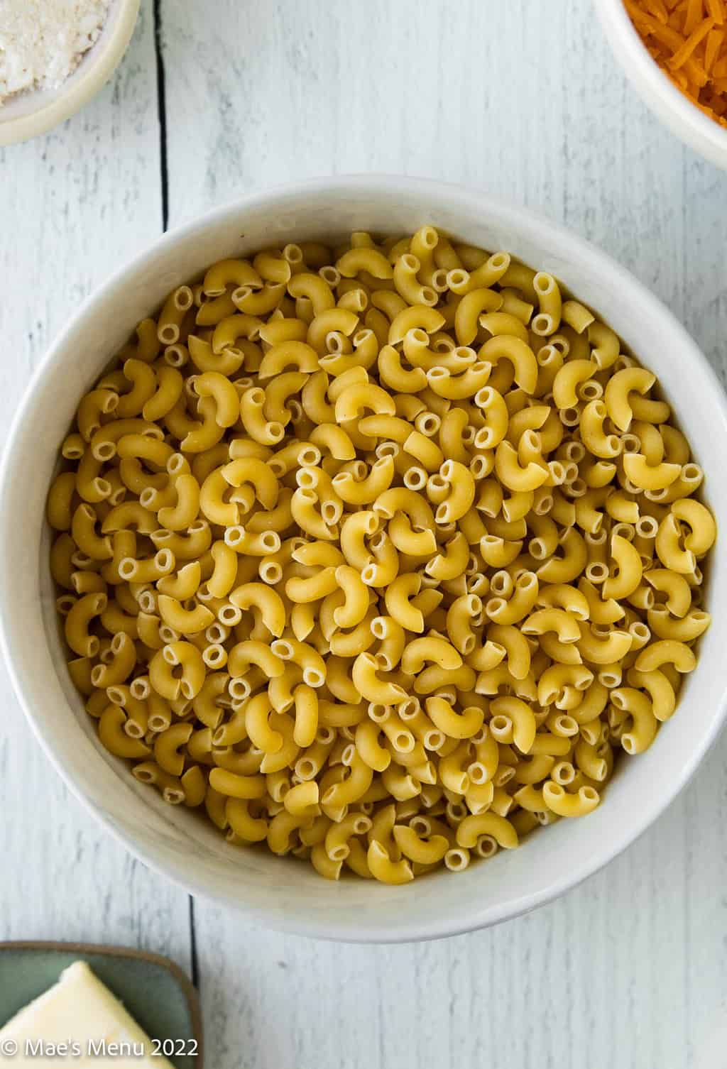 An overhead shot of a bowl of uncooked macaroni in a bowl.