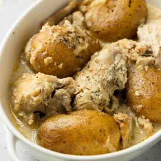 An up-close angled shot of a white bowl of instant pot chicken and potatoes.