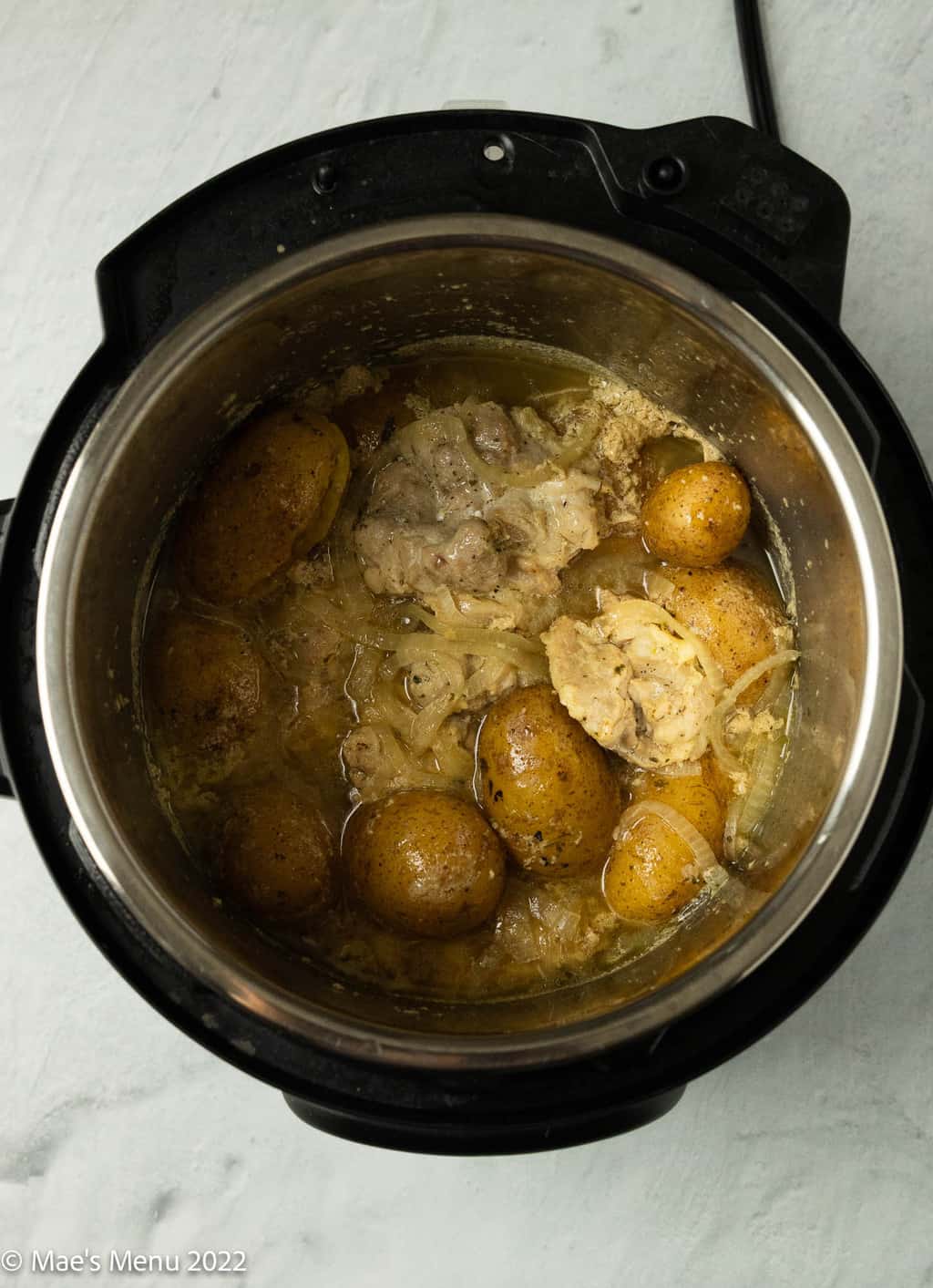 An overhead shot of a Instant pot full of chicken and potatoes.