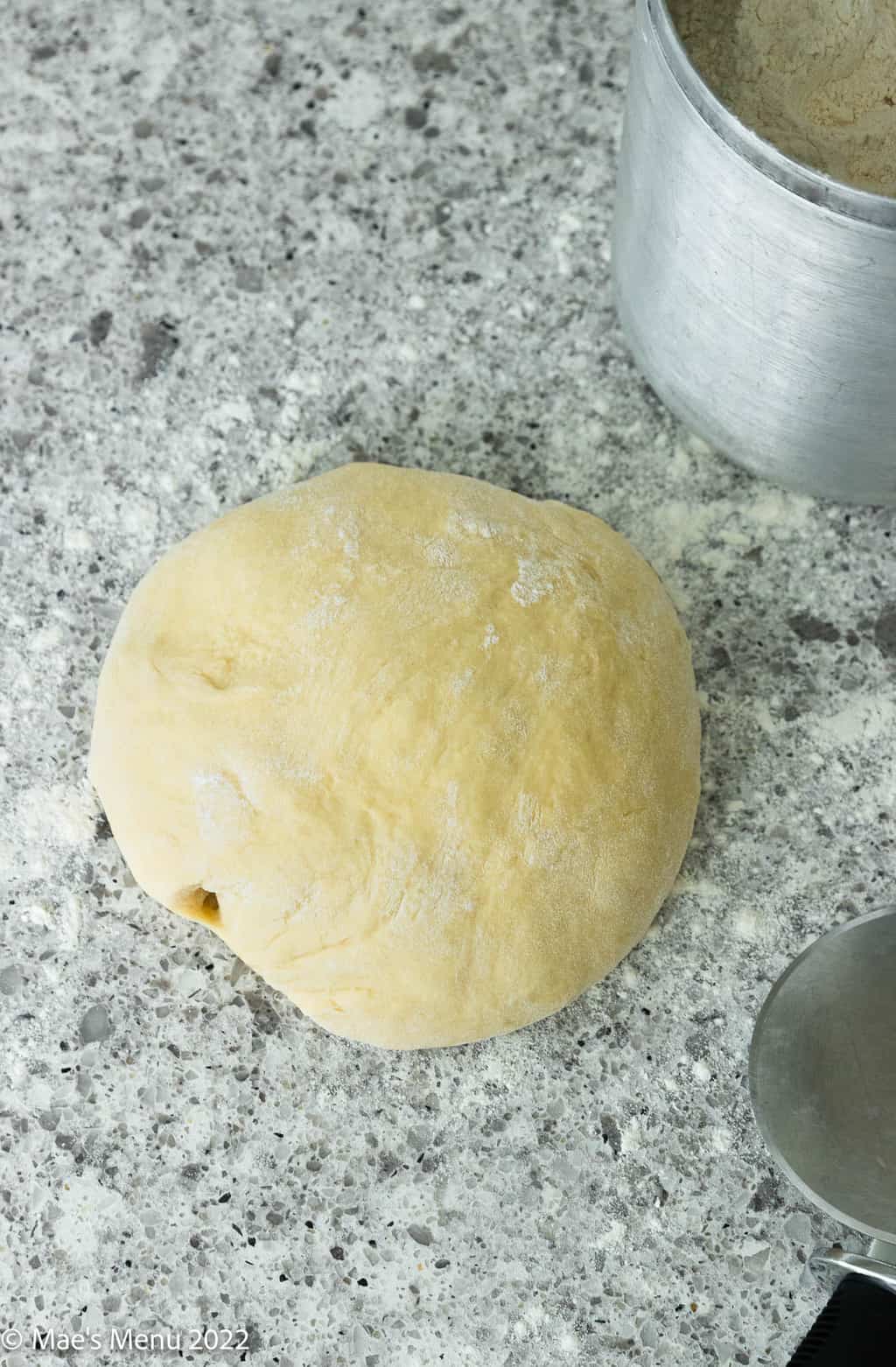 An overhead shot of a ball of bread dough on the counter.