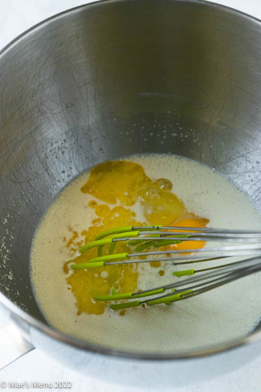 A mixing bowl with milk, yeast, butter, and eggs.