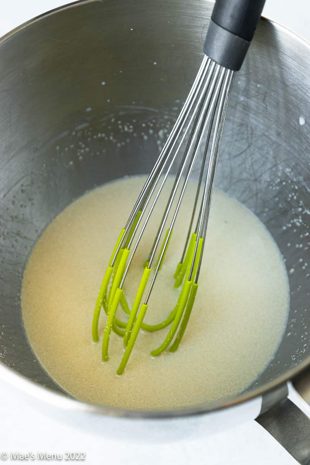 A mixing bowl with yeast and milk.