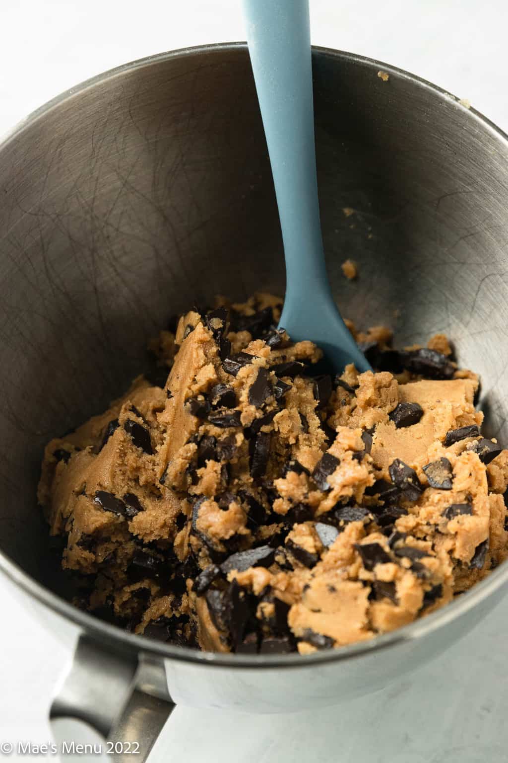 A mixing bowl with chocolate chip cookie dough.