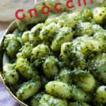 A pinterest pin for pesto gnocchi with an up-close shot of a bowl of the gnocchi.
