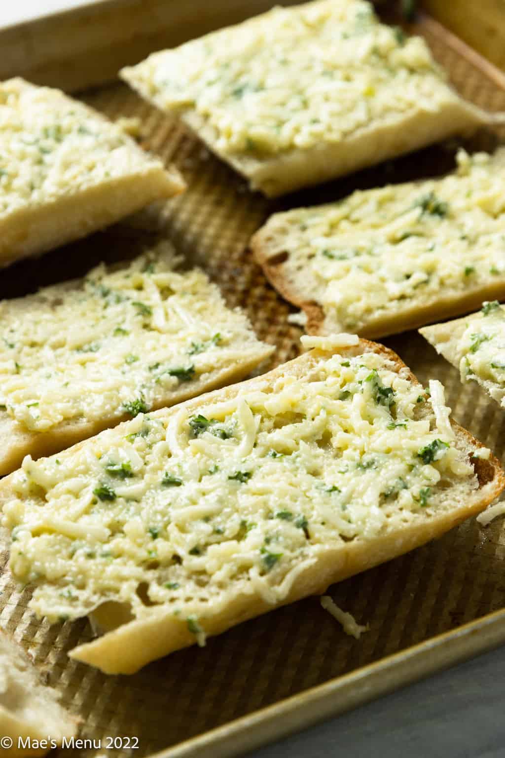 An up-close shot of small pieces of bread brushed with garlic butter.