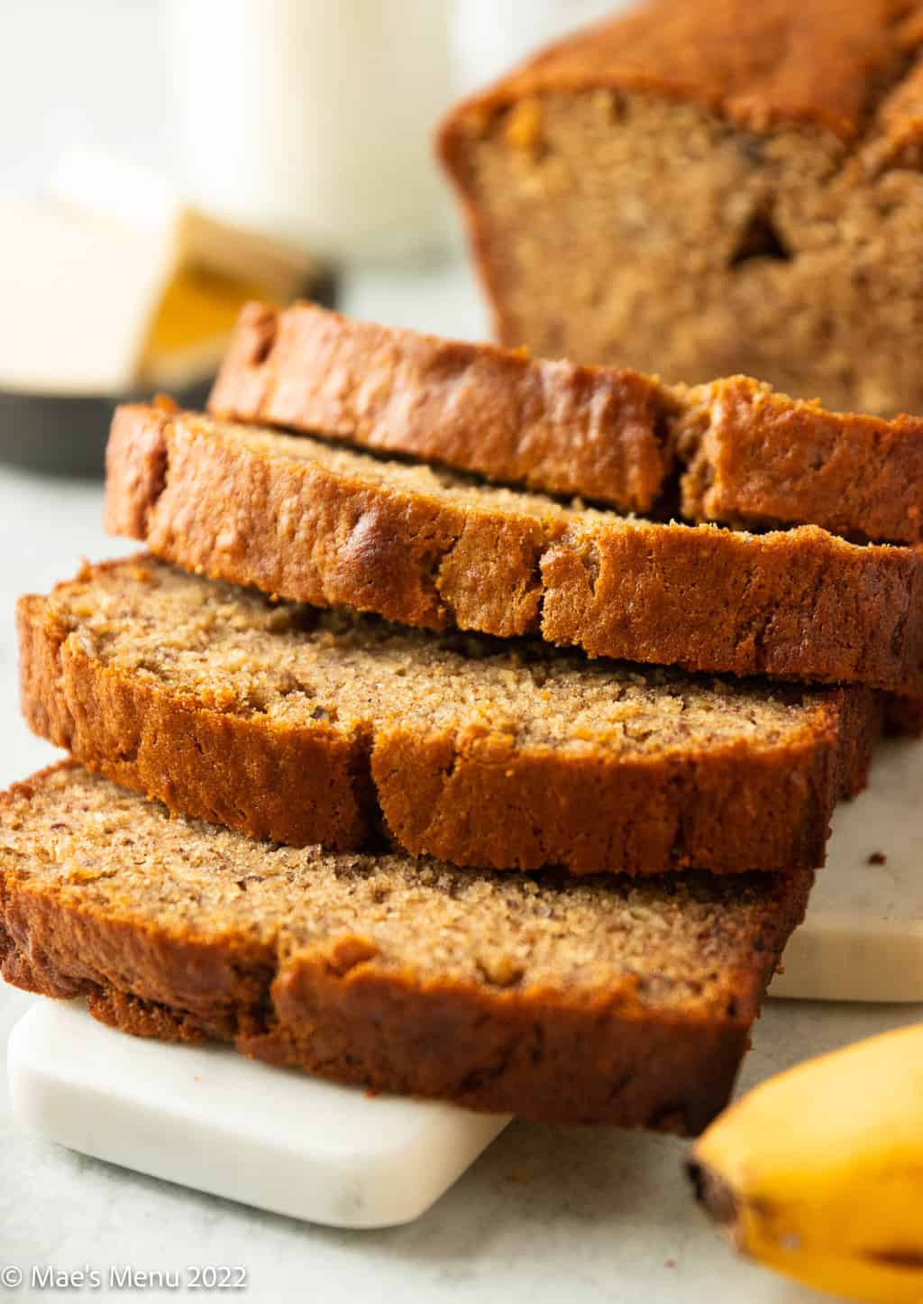 Up-close shot of sliced banana bread on a serving board.