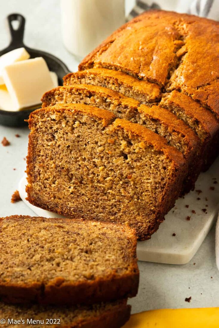 Sliced banana bread with butter and milk.