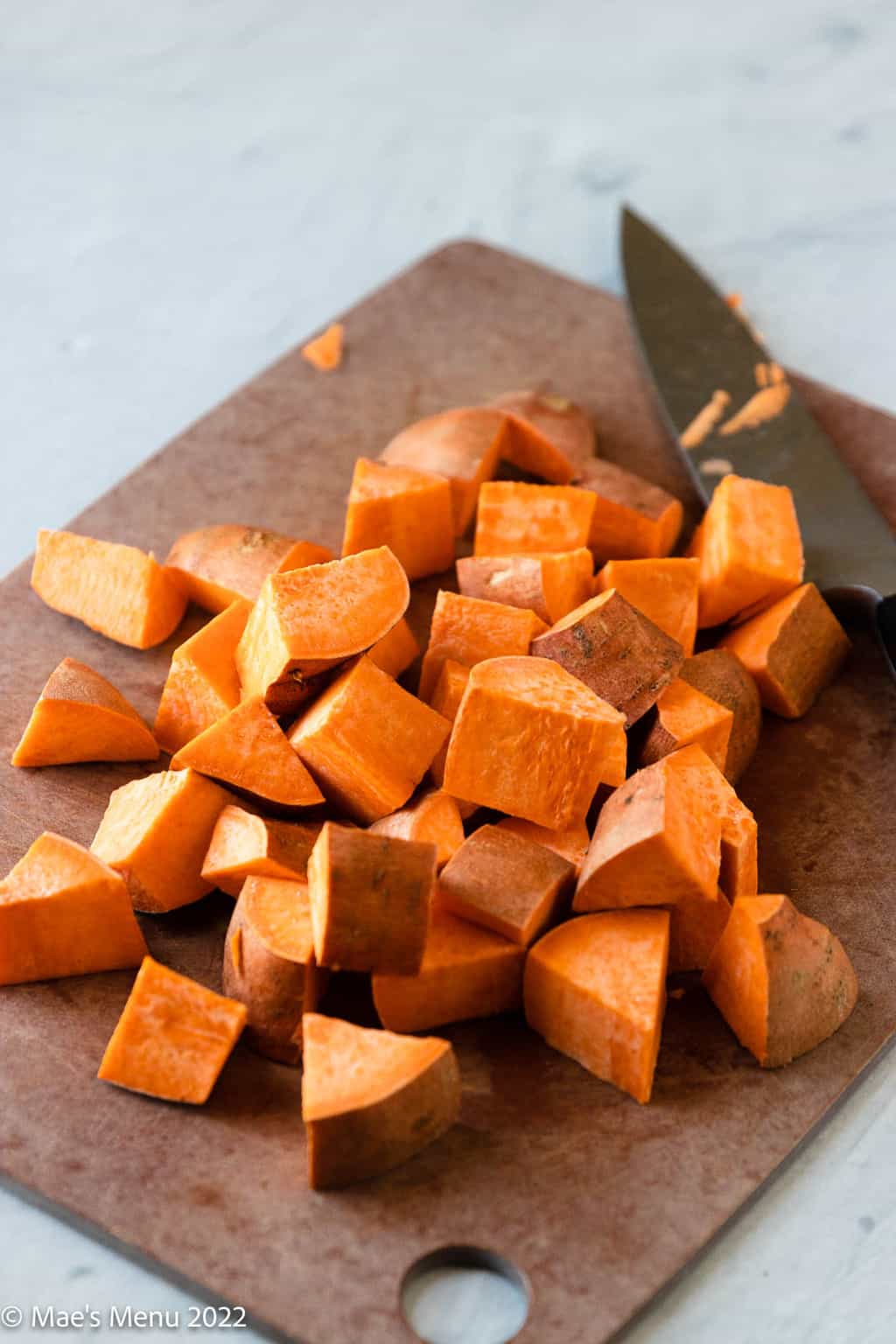 A cutting board of cubed sweet potatoes.