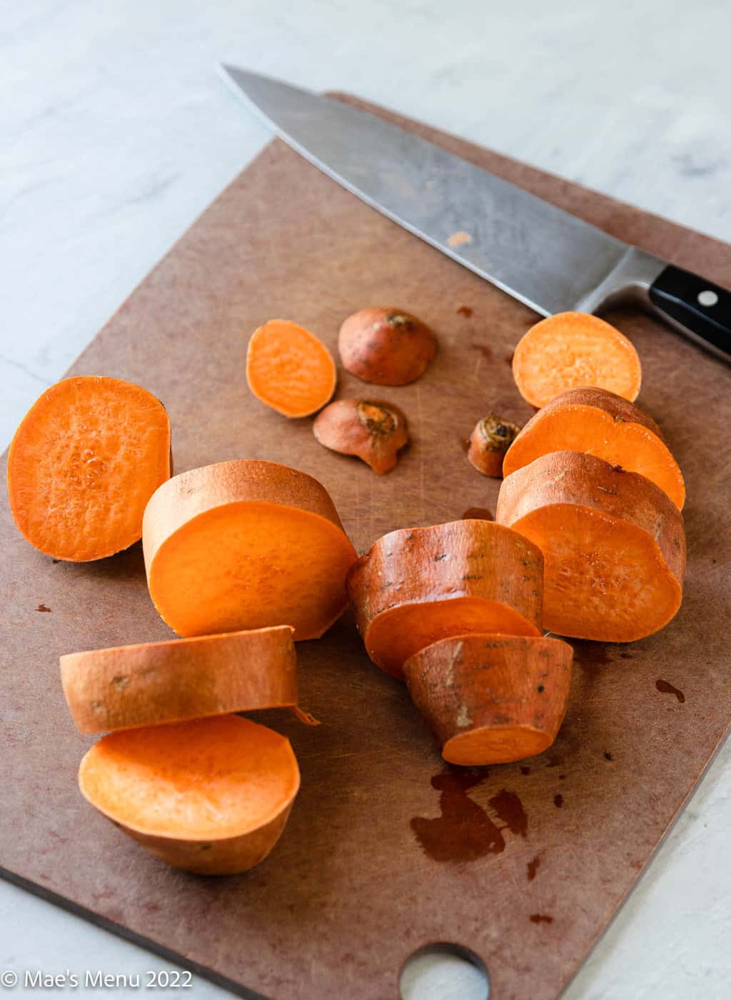 Sliced up sweet potatoes on a cutting board.