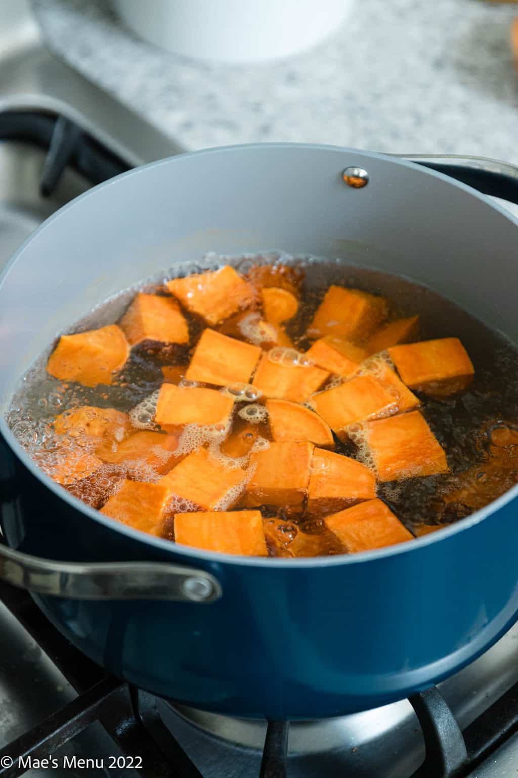 A dutch oven of sweet potatoes boiling.