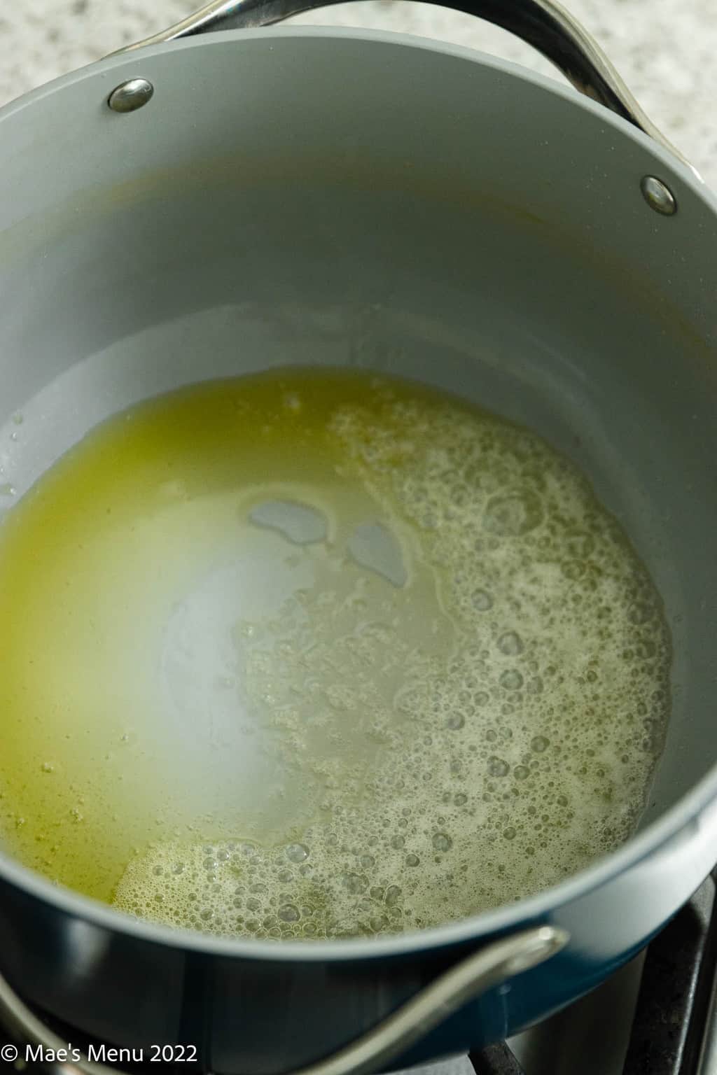 An overhead shot of a pan of Dutch oven with melted butter and olive oil.