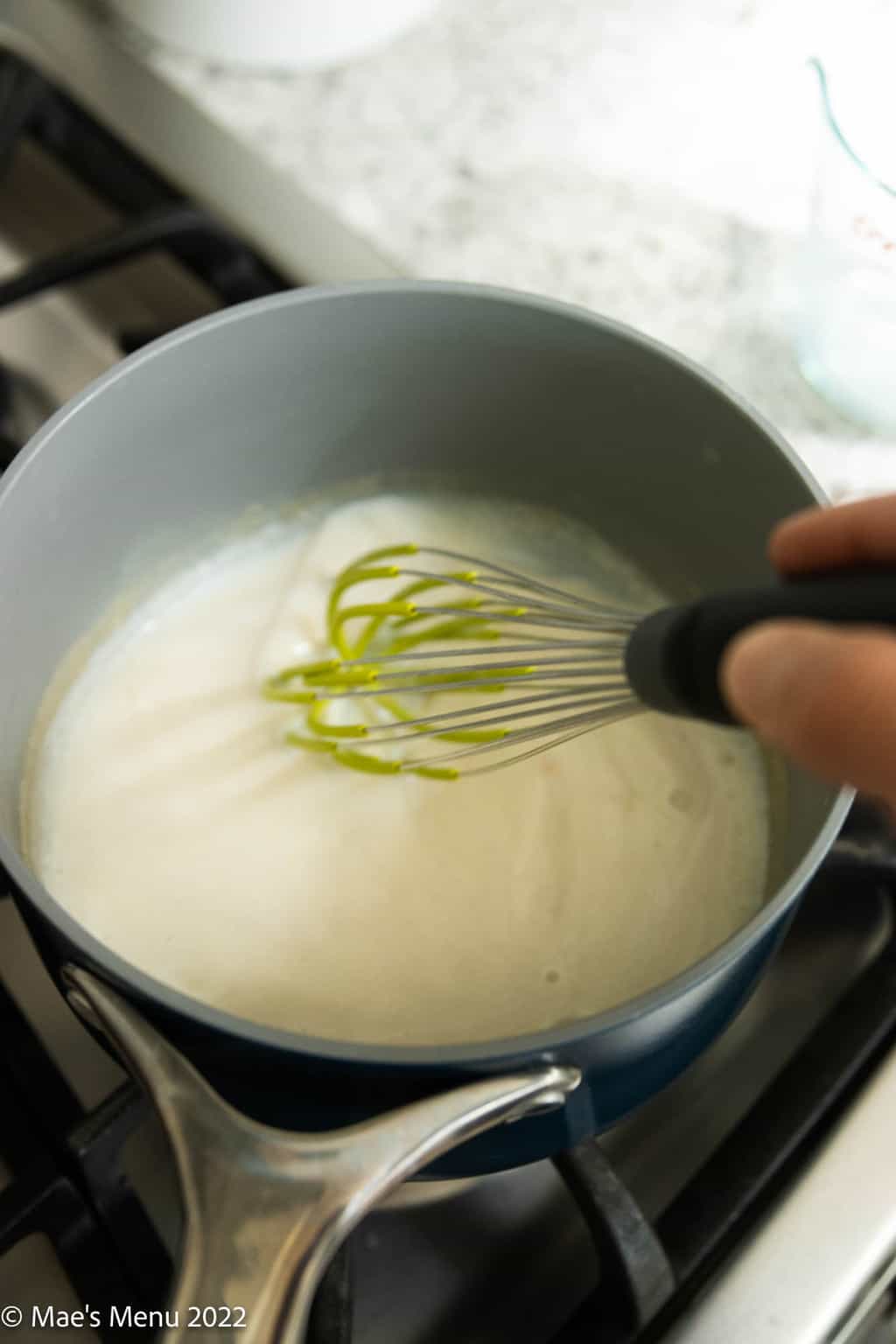 Whisking a roux in a saucepan.