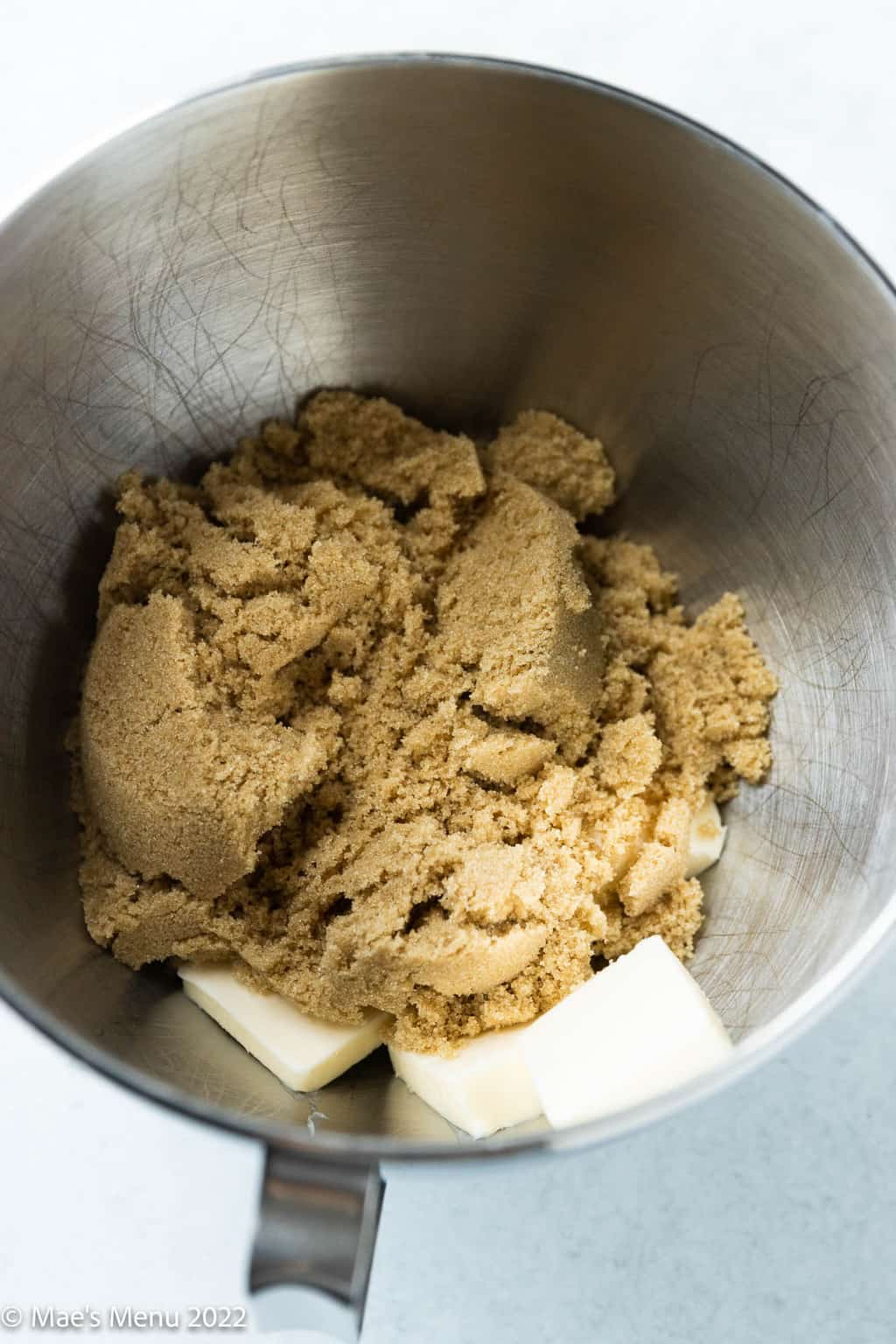 A mixing bowl with butter and brown sugar.
