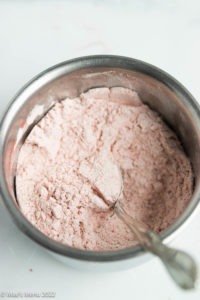 Flour mixed with strawberry powder in a small mixing bowl.
