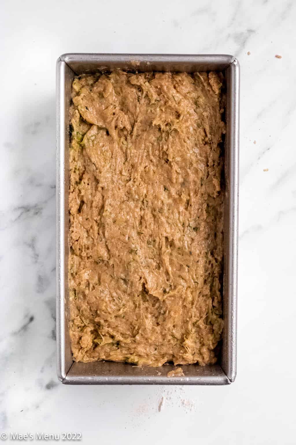 An overhead shot of a loaf pan of gluten-free zucchini bread before baking.