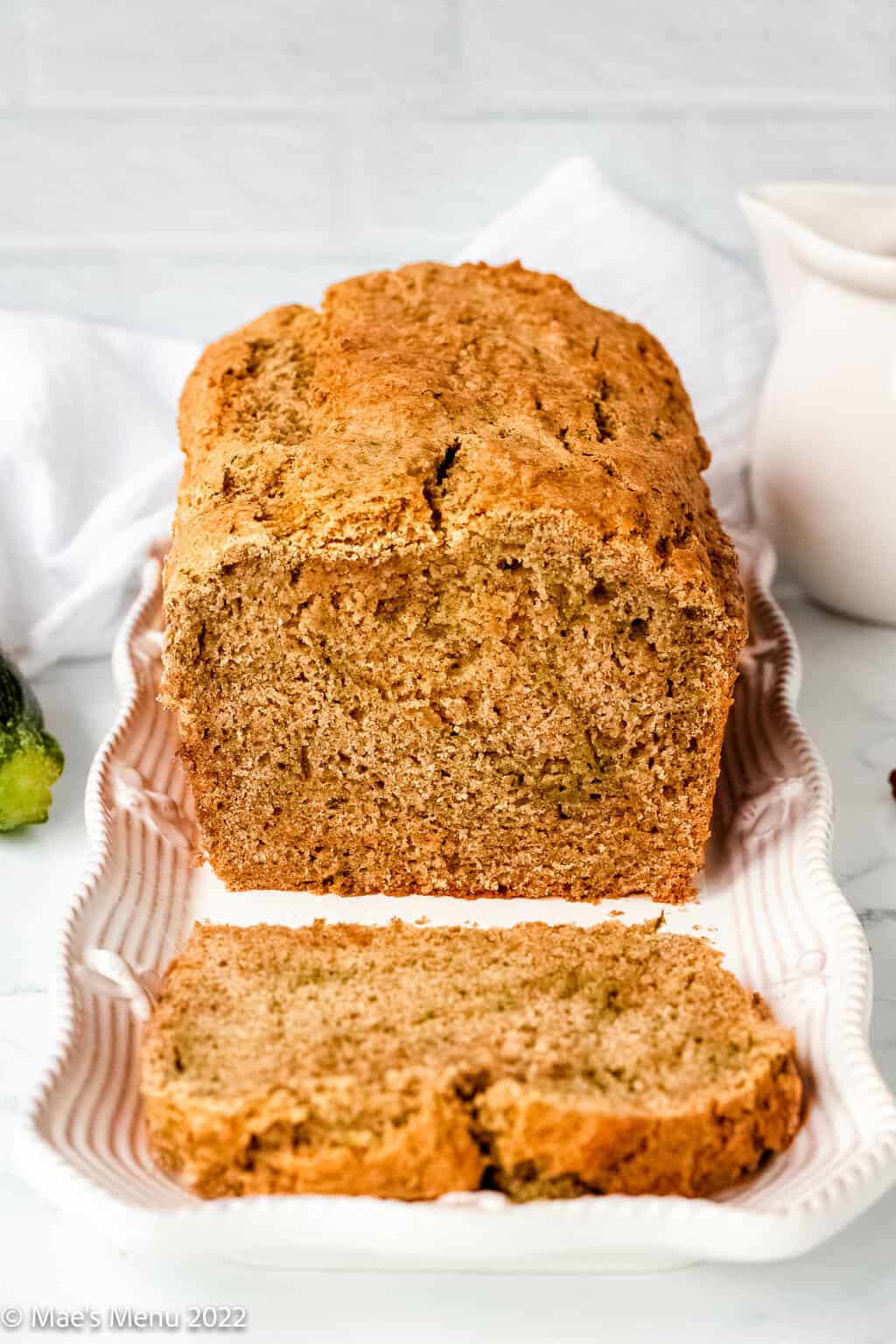A plate of a slice and loaf of gluten-free zucchini bread