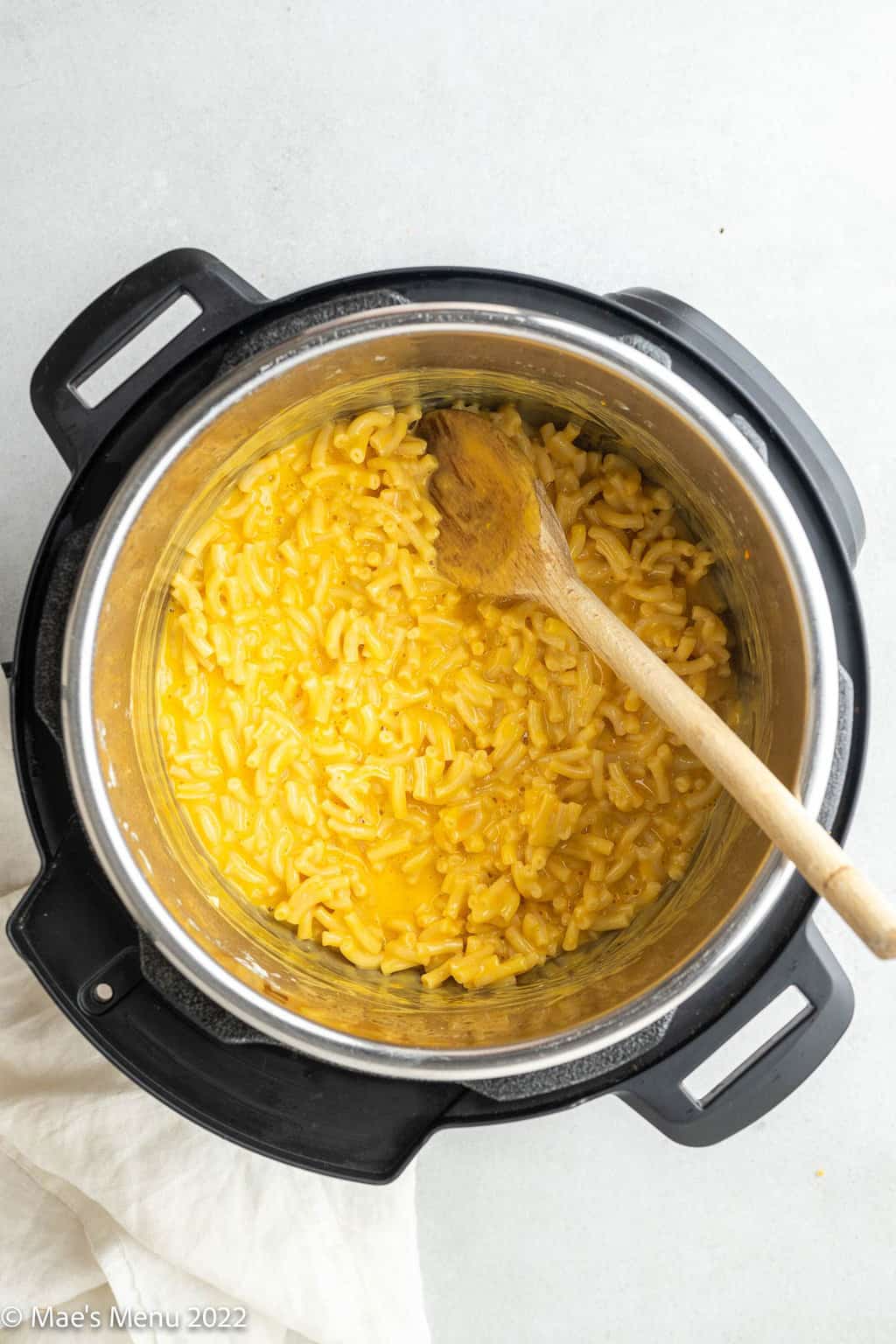 Kraft mac and cheese and a wooden spoon in the Instant Pot.