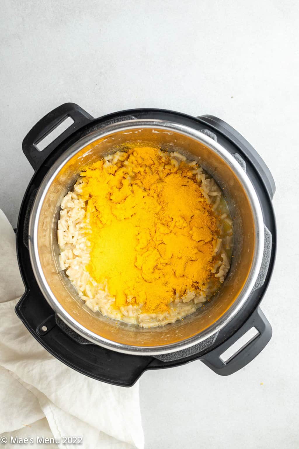 Macaroni in the Instant Pot with powdered cheese sprinkled on top.