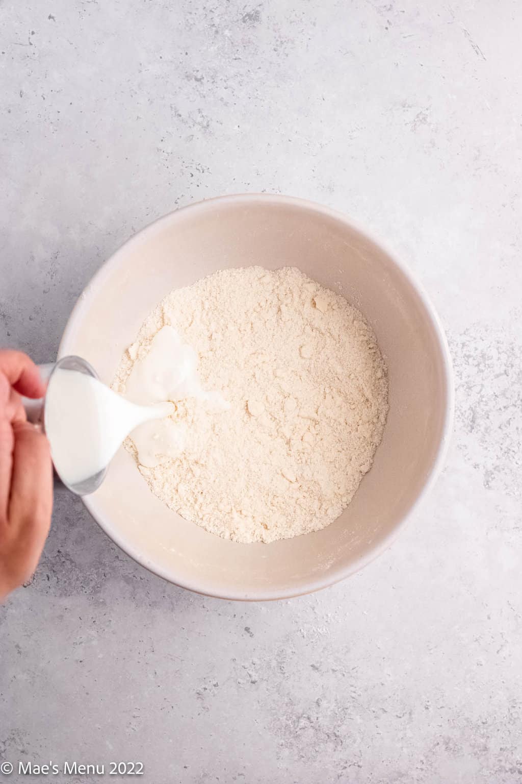 Pouring buttermilk into the buttery flour mixture.