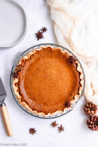 A baked diary free pumpkin pie with pine cones and star anise.