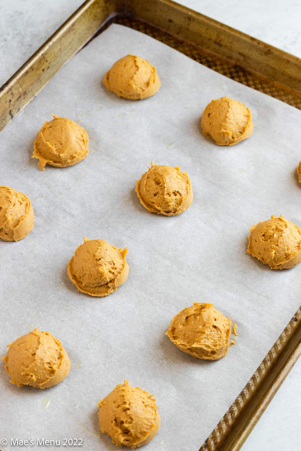 Scooped gluten-free pumpkin cookies on a prepared baking sheet.