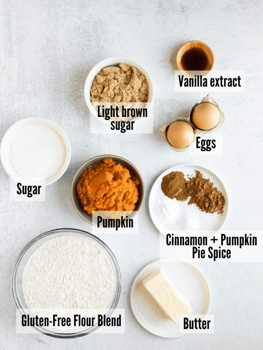 All of the ingredients for gluten-free pumpkin cookies: brown sugar, vanilla extract, eggs, cinnamon, pumpkin pie spice, pumpkin, sugar, gluten-free flour blend, and butter.