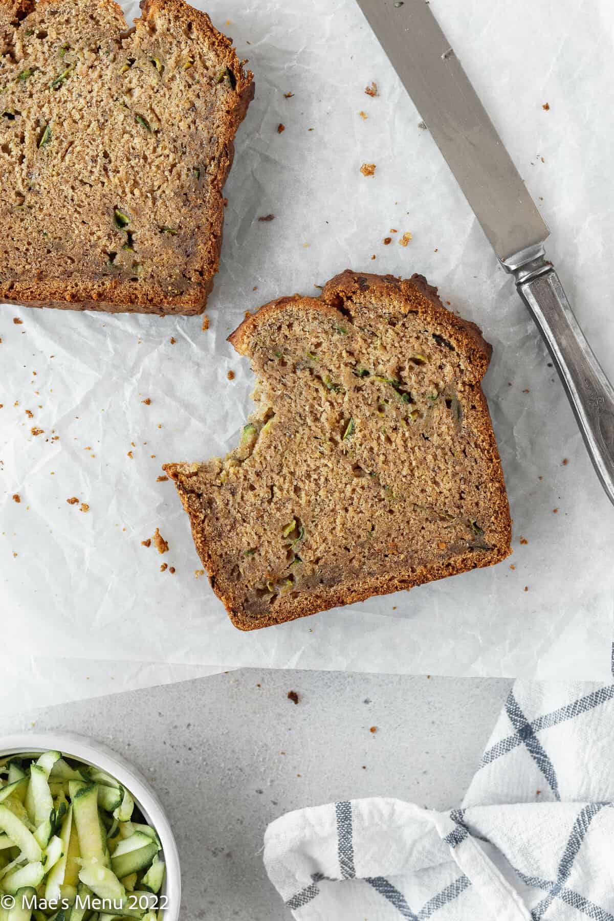 Two pieces of banana zucchini bread on a white background.