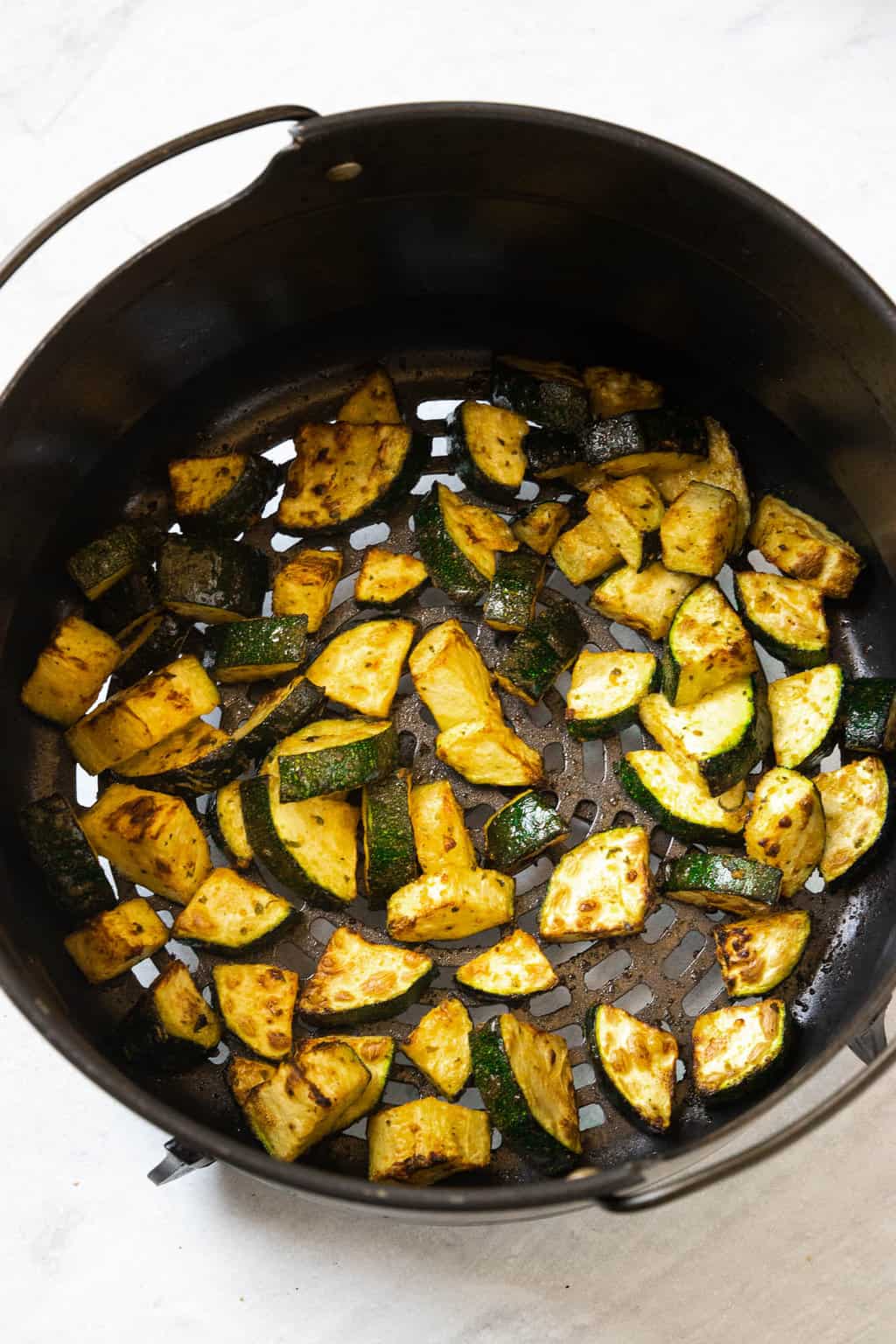 Squeezing lemon into a bowl of air fryer zucchini