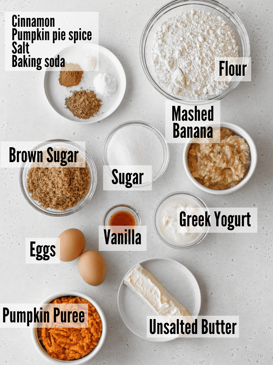 All of the ingredients for banana pumpkin muffins: pumpkin puree, mashed banana, butter, eggs, vanilla, Greek yogurt, mashed banana, sugar, brown sugar, spices, and flour.