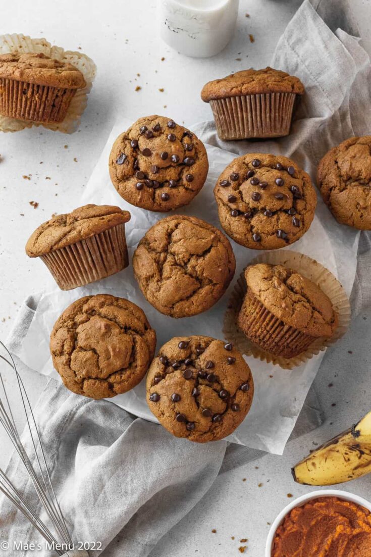 An up-close overhead shot of banana pumpkin muffins on parchment paper and a napkin on the counter.