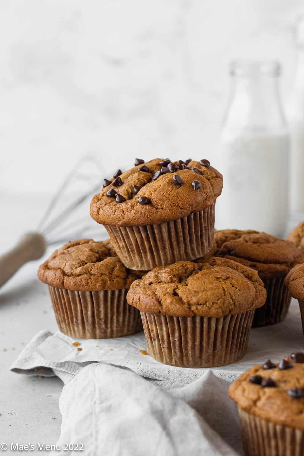 A stack of banana pumpkin muffins; a few of the muffins have chocolate chips on them.
