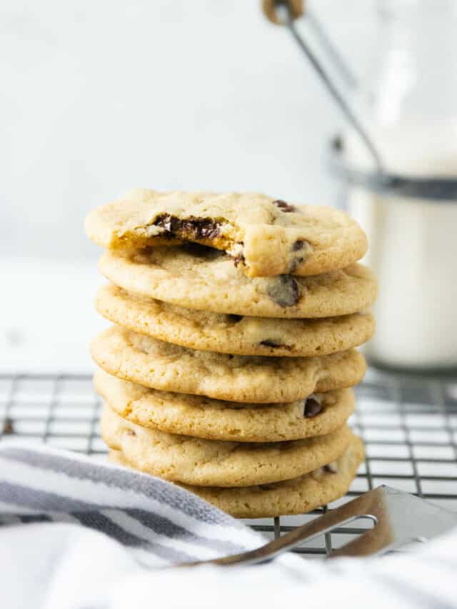 A stack of dairy free chocolate chip cookies on a cooling rack.
