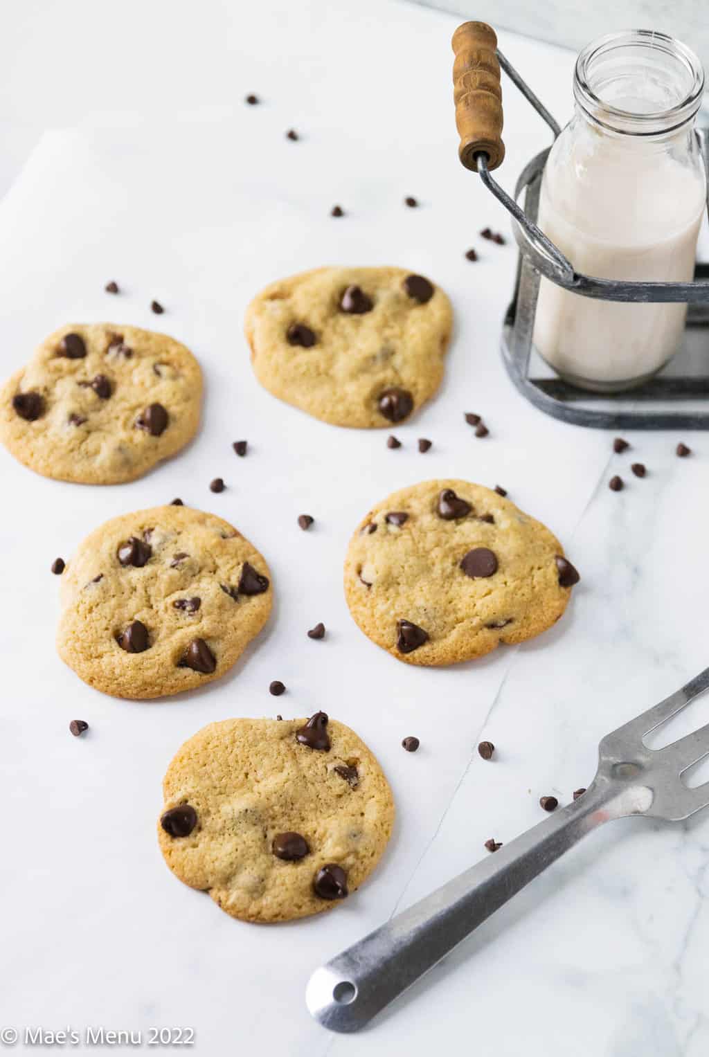 Dairy free chocolate chip cookies on parchment paper with mini chocolate chips.
